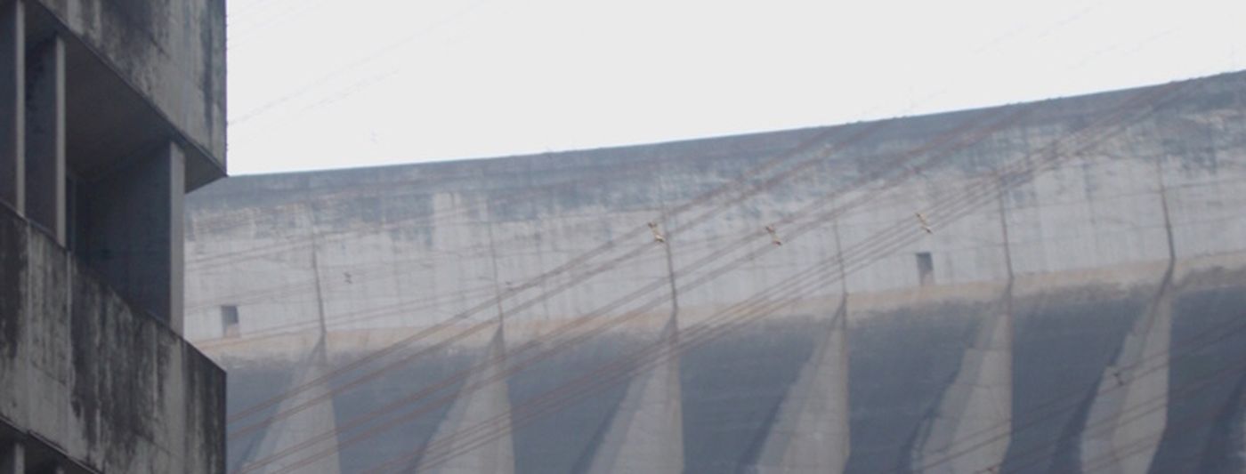 Canteiro de obra com a barragem de Itaipu ao fundo